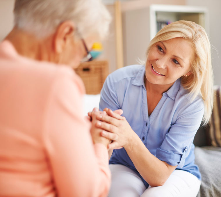 A woman engages in conversation with an older woman.